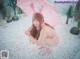 A woman in a pink bunny costume holding an umbrella.