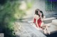 A couple of women sitting on top of a couch next to a pool.