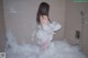 A woman is taking a bath in a bathtub filled with foam.