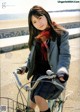 A young woman riding a bike on the beach.