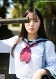 A woman in a school uniform holding a baseball bat.