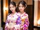 Two young women in kimonos standing next to each other.